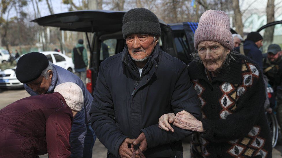 Two elderly people evacuating in Irpin