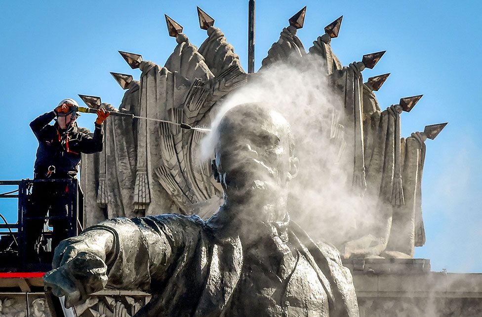 A worker cleans a statue of Vladimir Lenin in Moscow Square in front of the House of Soviets in St Petersburg, Russia, on 21 April 2022