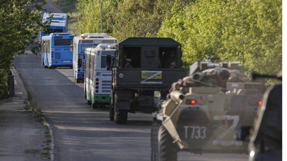 Russian military vehicles escort buses with Ukrainian fighters