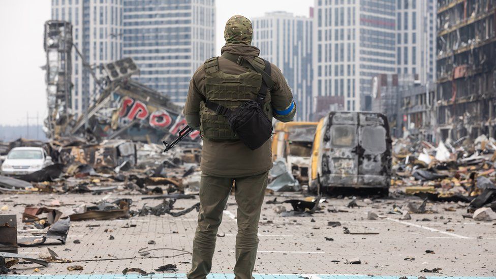 A soldier looks at a destroyed building