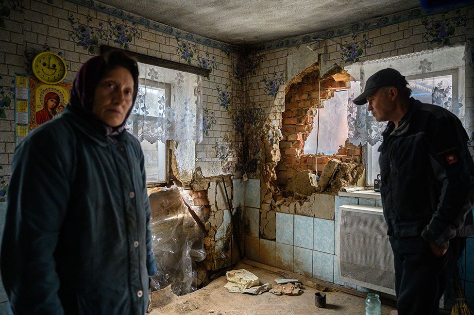 Tanya Los and her husband Valery survey the damage to their house caused by a rocket in the village of Mala Tomachka, south of Zaporizhzhia, a city in south-eastern Ukraine, on 19 April 2022